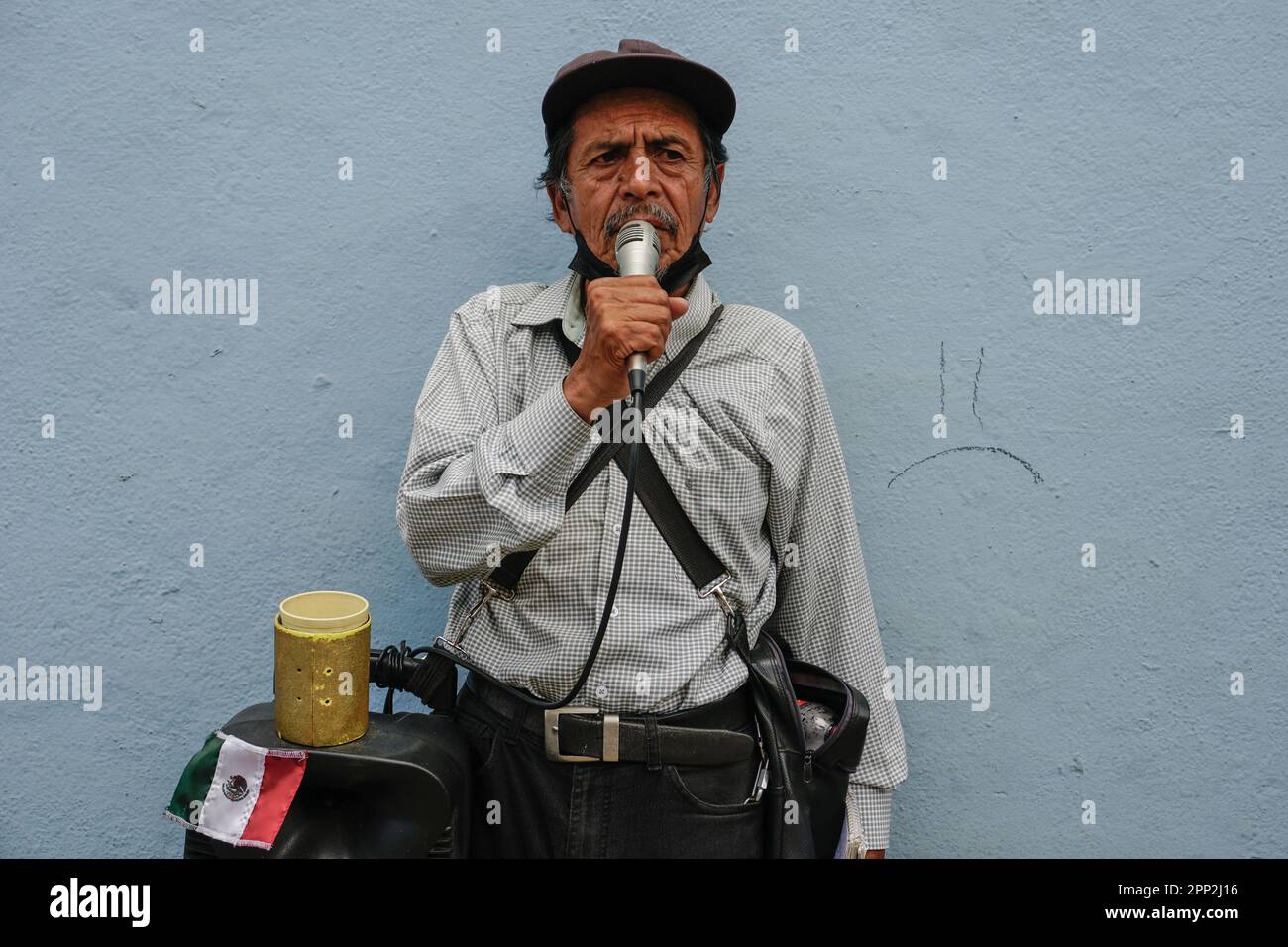 Arturo Pérez singt am 22. September 2022 in einer Straße in Oaxaca, Mexiko. Pérez, der mit seiner Abfindung einen Lautsprecher und ein Mikrofon gekauft hat, singt jeden Morgen. „Ich bin jetzt sehr alt und die Leute stellen mich nicht mehr ein, um zu arbeiten“, sagt er. "Ich mochte schon immer Musik. Mein Großvater spielte Gitarre, als ich klein war.“ (Ena Aguilar Peláez/Global Press Journal) Stockfoto