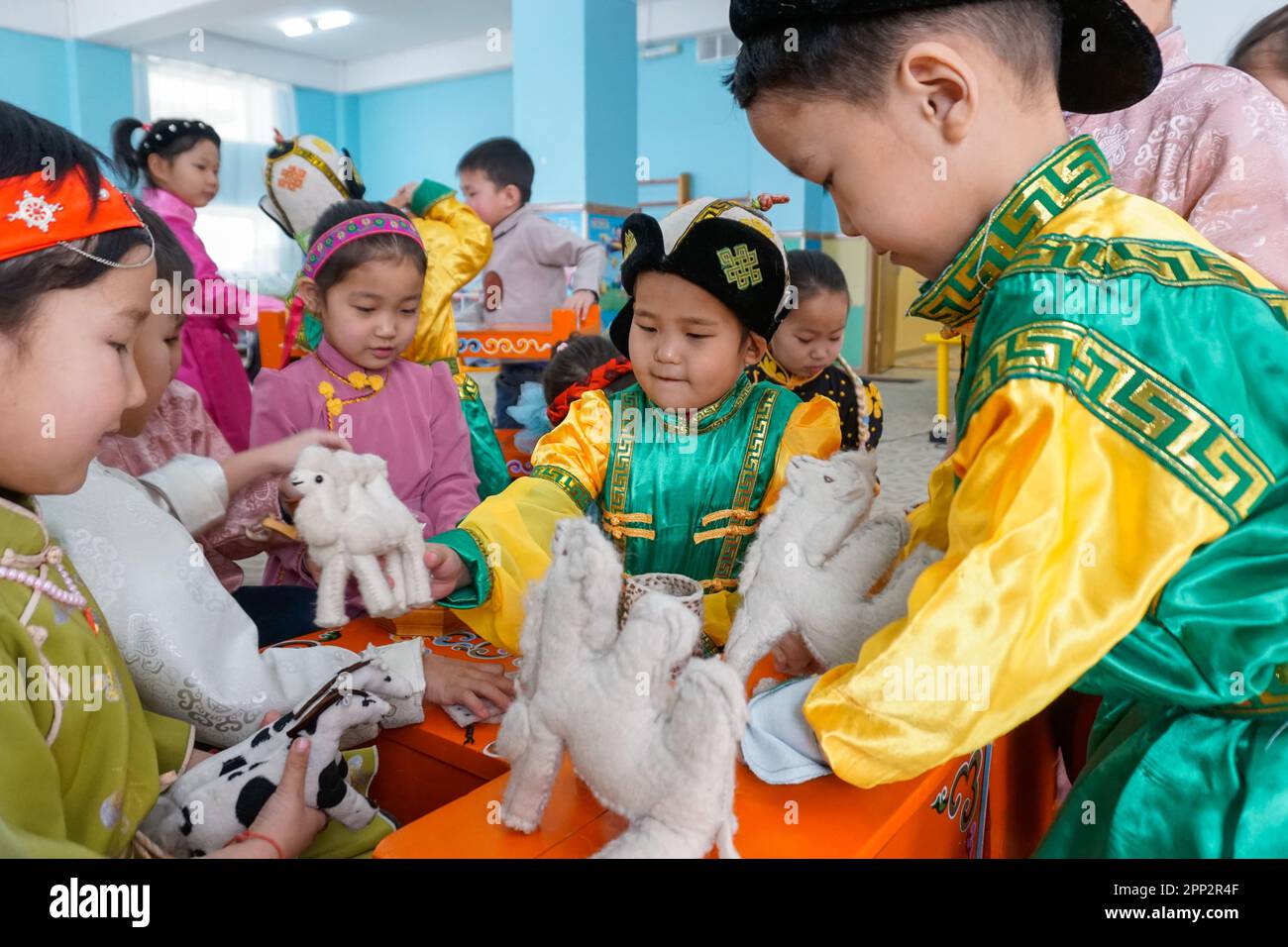 Kindergärtner in traditioneller Kleidung spielen mit Wollspielzeug während eines Sonderkurses für Tsagaan Sar, das mongolische MondNeujahr, in Dalanzadgad, Provinz Umnugovi, Mongolei am 17. Februar 2023. (Uranchimeg Tsoghuu/Global Press Journal) Stockfoto