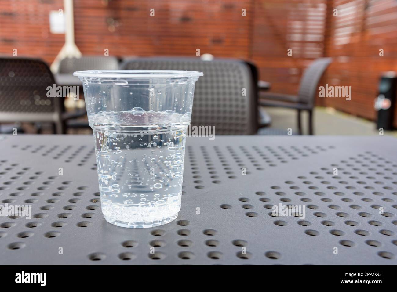 Wasser in einem Plastikbecher auf einem Restauranttisch Stockfoto