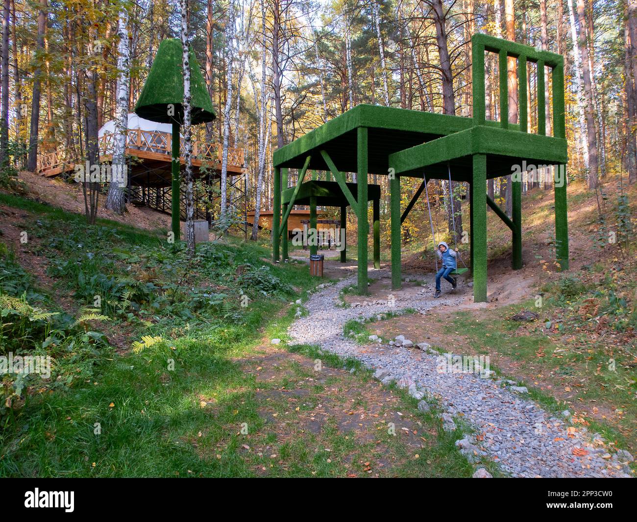 Ein Park mit riesigen Dekorationen in Form von Tisch und Stühlen, dreimal so groß wie ein Mann Stockfoto