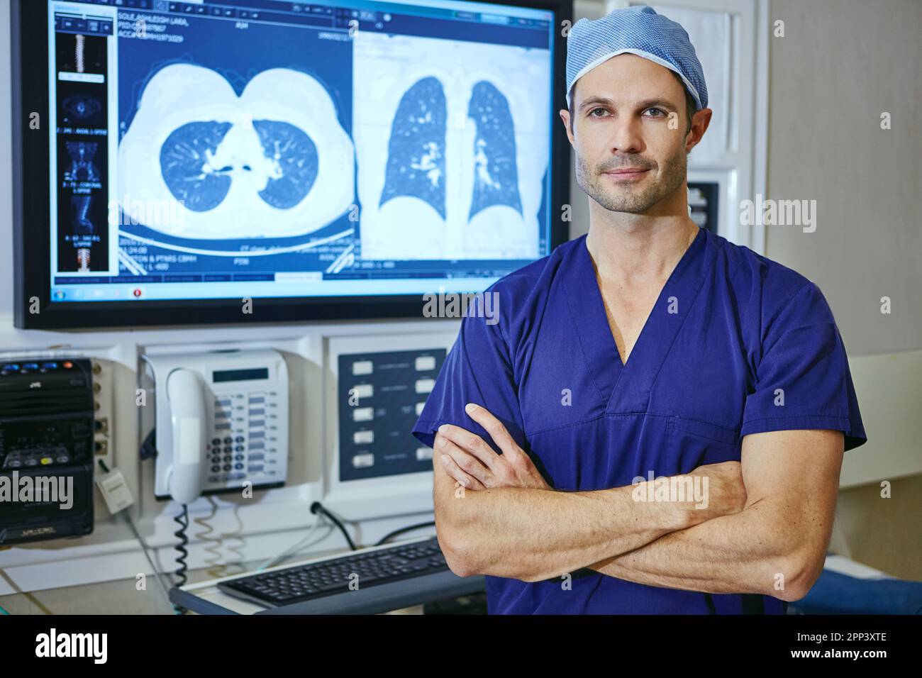 Lassen Sie mich herausfinden, was wirklich mit Ihnen nicht stimmt. Porträt eines männlichen Chirurgen, der mit gekreuzten Armen und einem medizinischen Scan im Hintergrund steht. Stockfoto