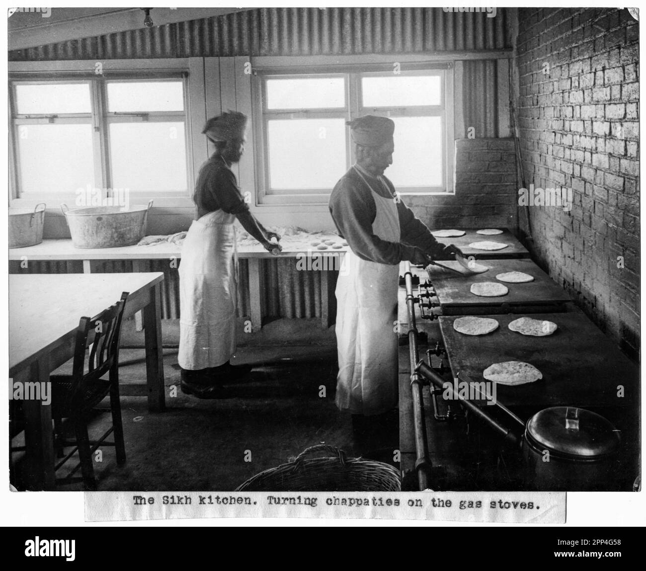 Auf diesem Foto sehen wir zwei Männer, die Chapatis (ein ungesäuertes Fladenbrot) in der „Sikh-Küche“ kochen. Mehrere Gebäude in Brighton wurden in i umgewandelt Stockfoto