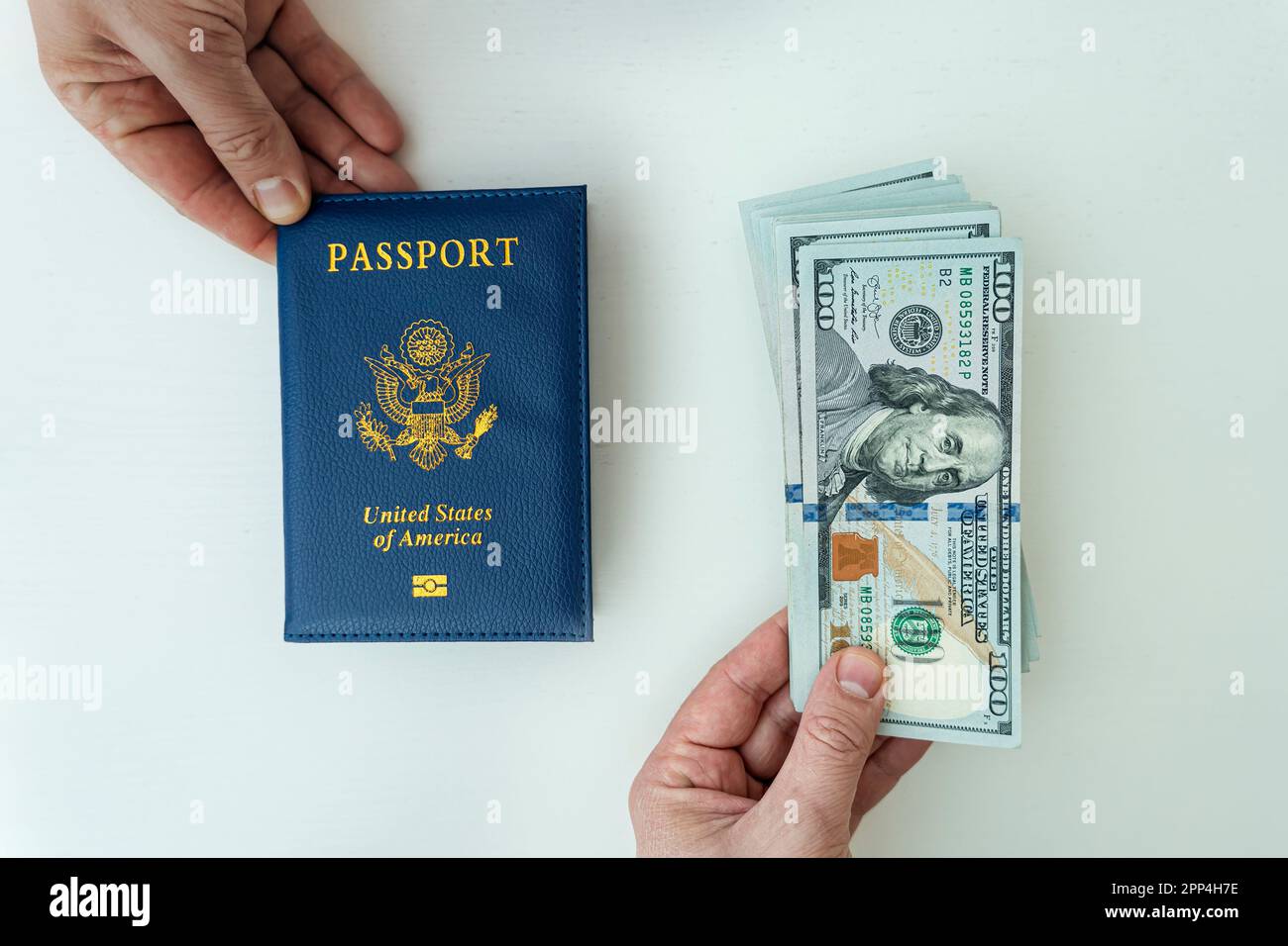 Hände mit russischem Pass und US-Dollar-Scheinen. Reisepassausstellung. Ein Bankdarlehen. Bestechung an der Grenze Stockfoto