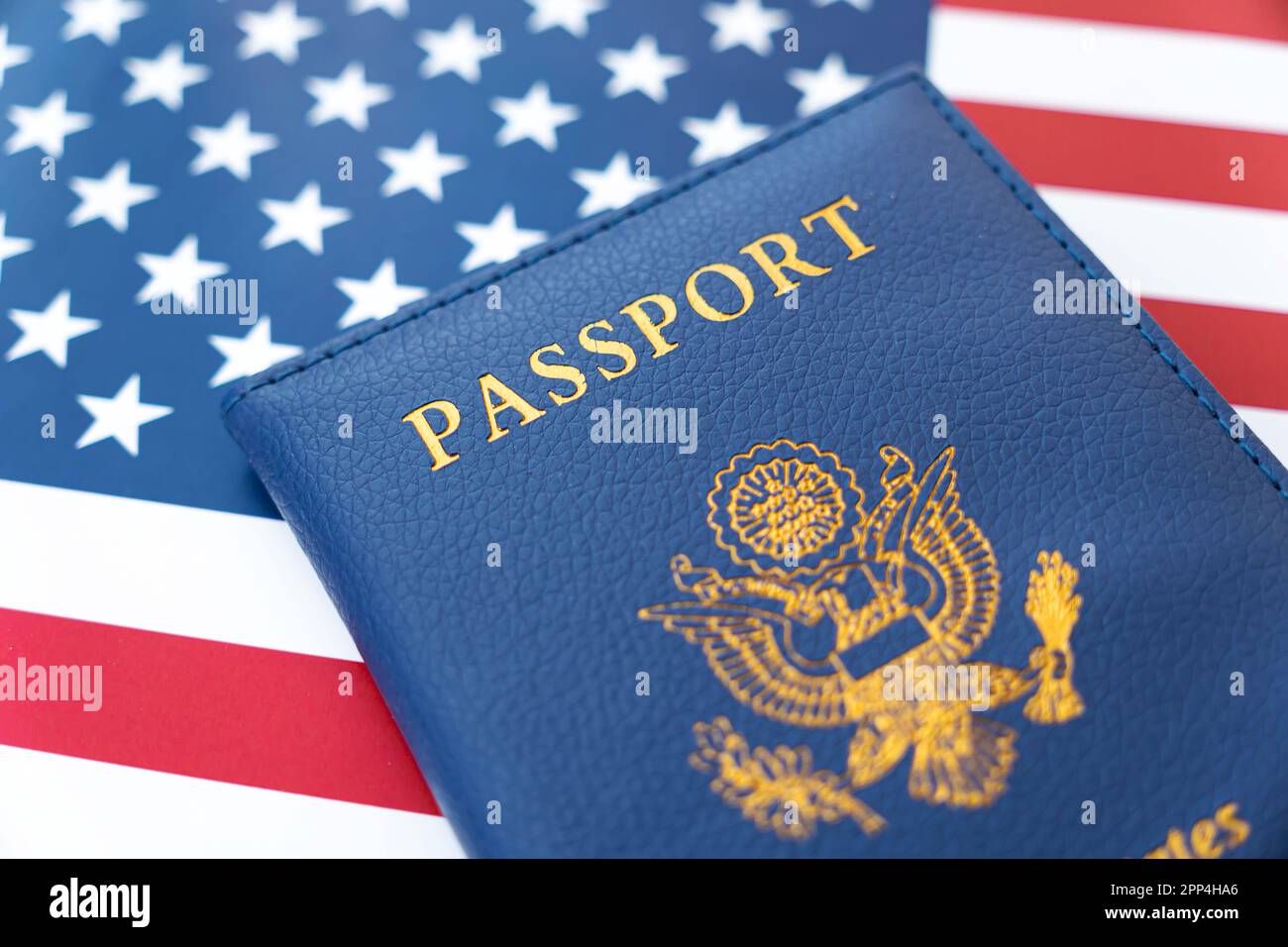 Neuer Blauer US-amerikanischer Pass auf US-Flagge Hintergrund . Konzept der Erlangung der US-Staatsbürgerschaft. Ein Bürger der Vereinigten Staaten. Stockfoto