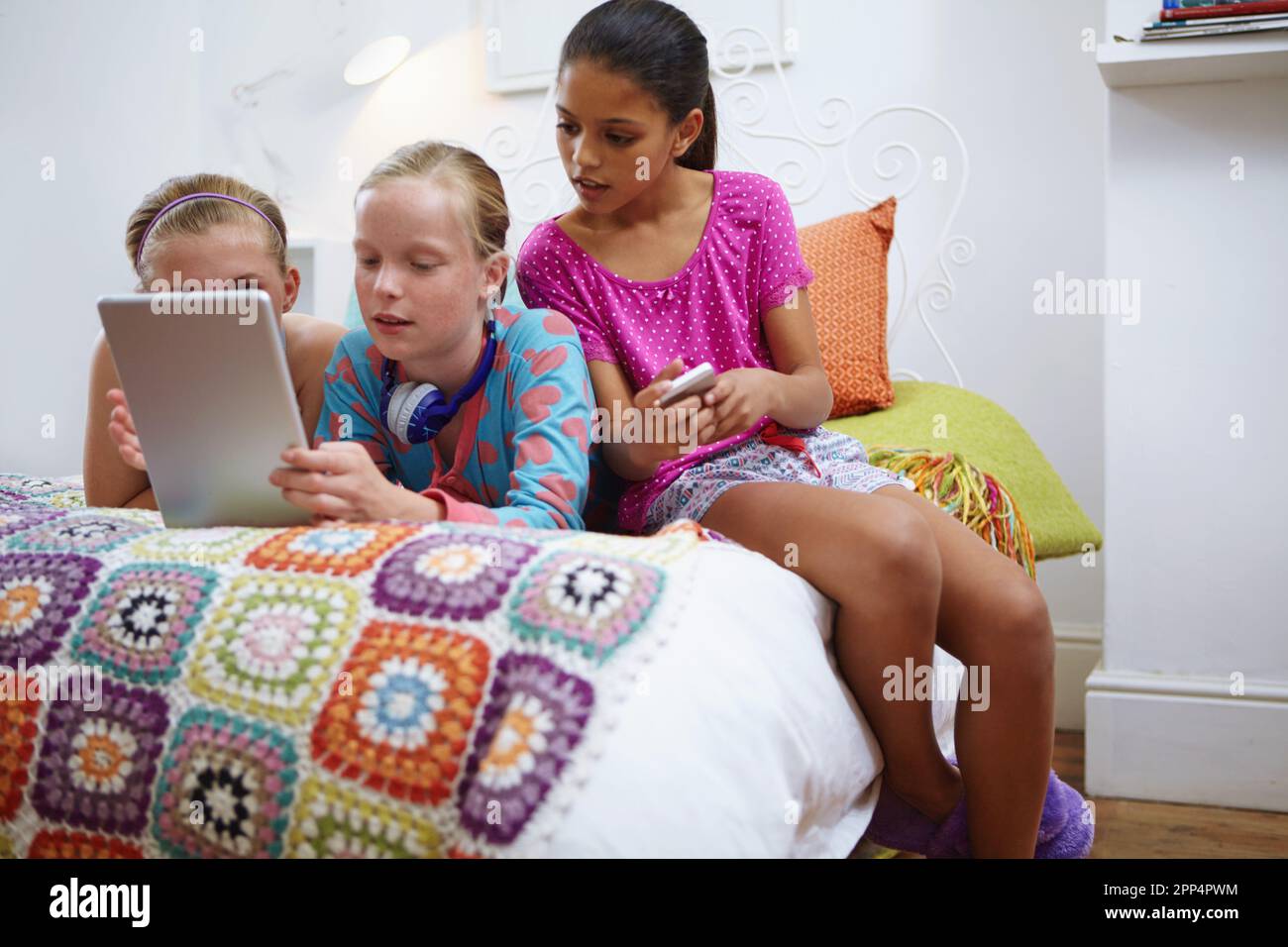 Sie schauen sich ihre Lieblings-rom-Com an. Eine Gruppe von Freunden im Teenageralter, die zusammen ein digitales Tablet verwenden. Stockfoto