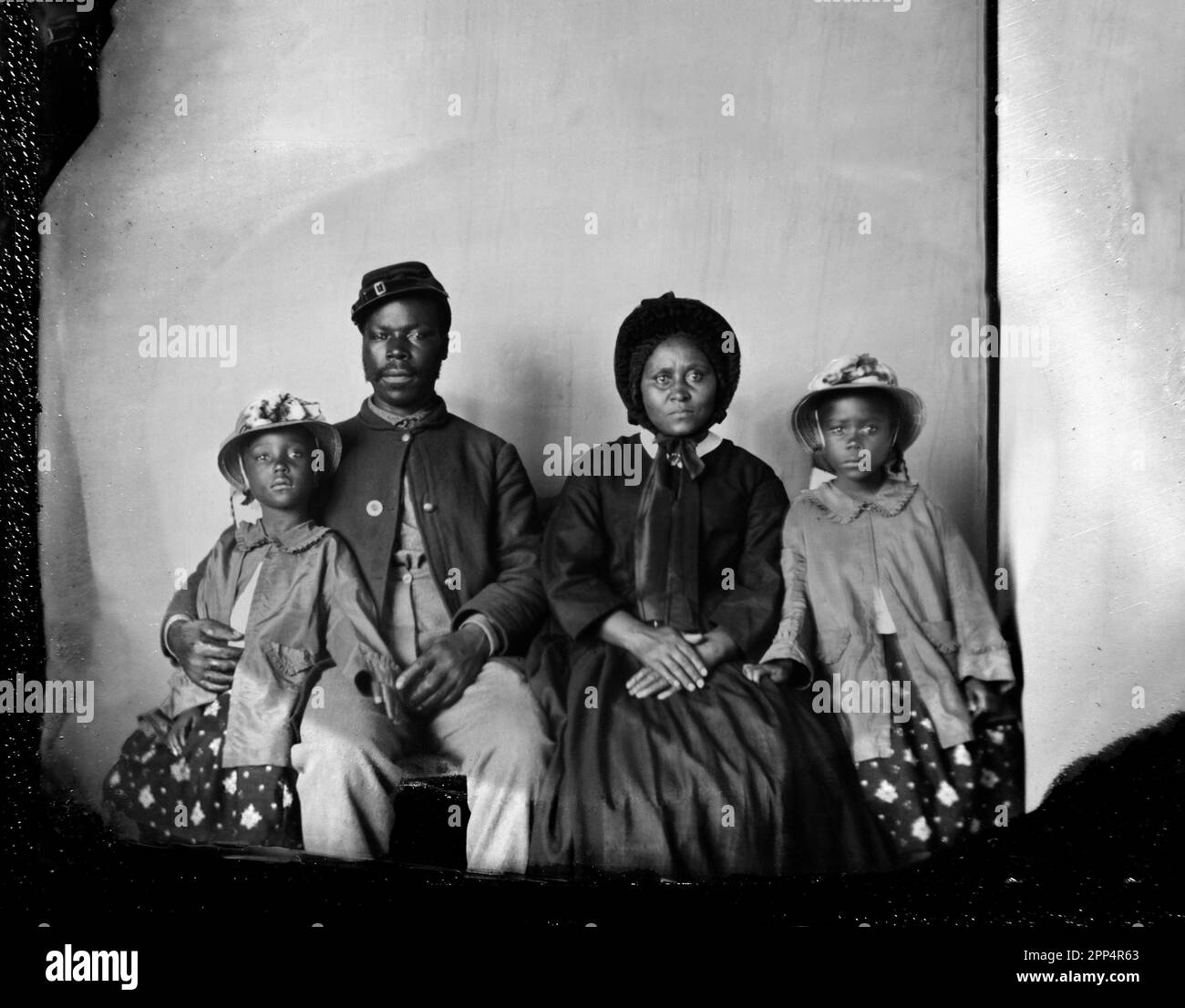 Sergeant Samuel Smith, afroamerikanischer Soldat der 119. USCT, in Unionsuniform mit seiner Frau Mollie und seinen Töchtern Mary und Maggie. Zwischen 1863 Uhr Stockfoto