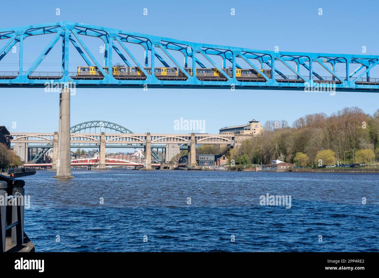 Ein Tyne and Wear Metro Zug überquert die Queen Elizabeth II Brücke in Newcastle Upon Tyne, Großbritannien, mit den anderen Brücken des Flusses Tyne dahinter. Stockfoto