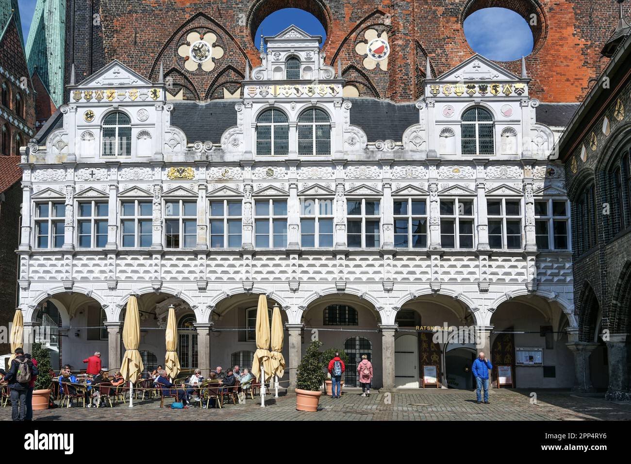 Lübeck, Deutschland, 17. April 2023: Renaissancefassade des historischen Rathauses von Lübeck vor anderen historischen Bauten in Ziegelarchitektur im ma Stockfoto