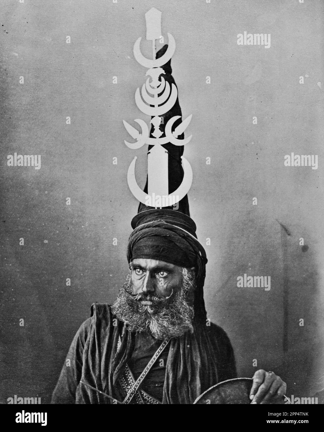 Porträt eines Sikh-Kriegers, auch bekannt als Nihang oder Akali, trägt einen kunstvollen konischen Turban, geschmückt mit Chakramen oder Kriegsquoits. Stockfoto