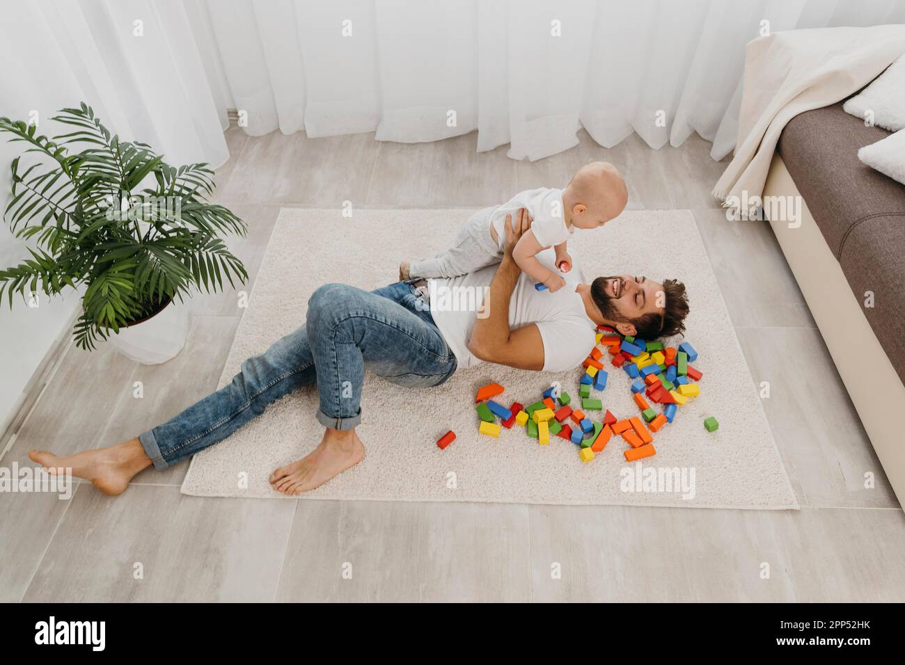 Hochwinkel Vater spielt Boden Haus mit Baby Stockfoto
