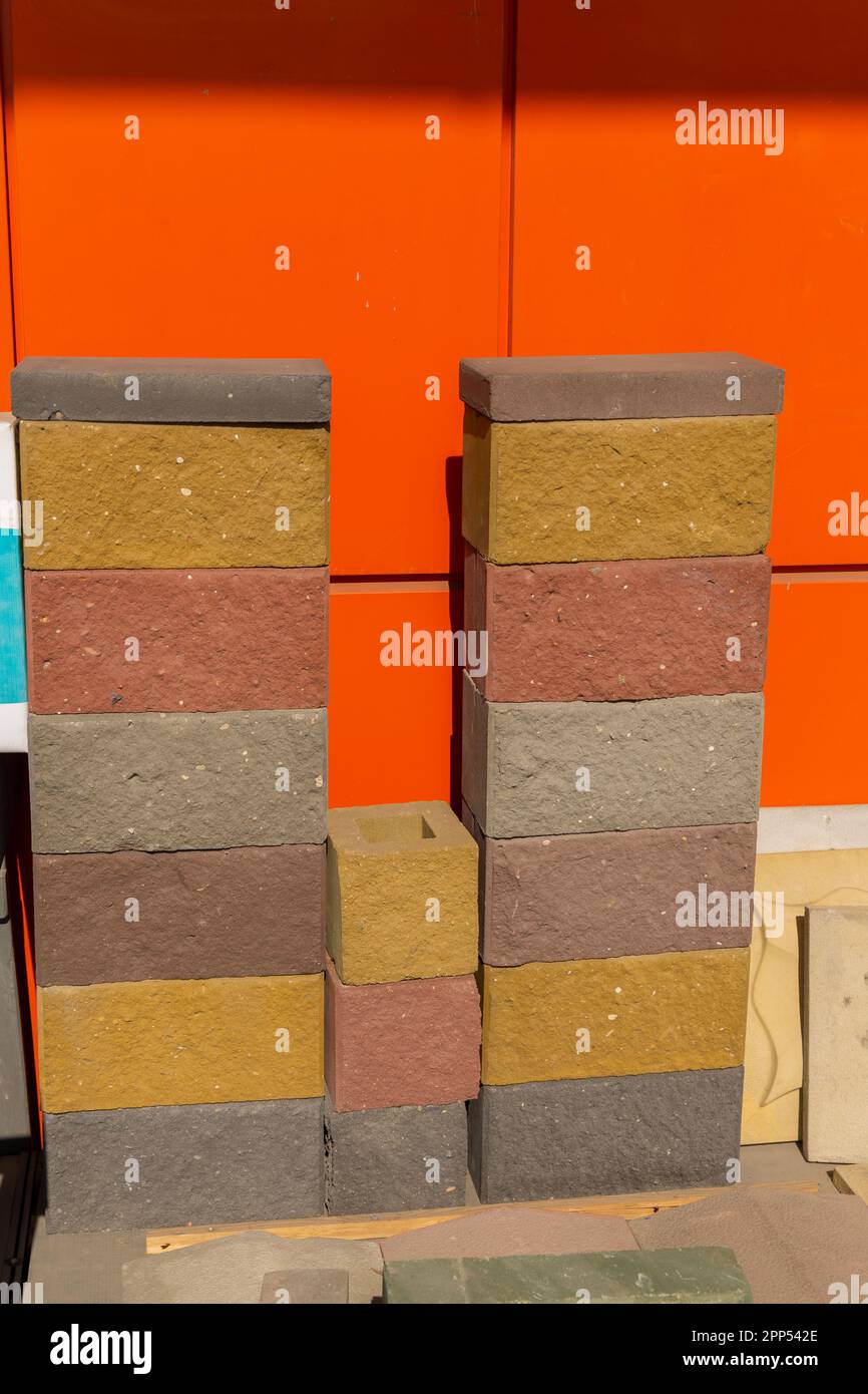 Beispiele mehrfarbiger Bausteine aus gepresstem Zement-Sand-Gemisch. Die Blöcke werden für den individuellen Aufbau und die dekorative Endbearbeitung verwendet. Stockfoto