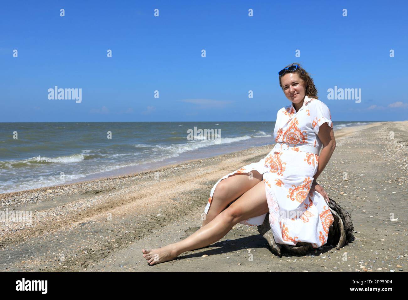 Eine Frau, die am Strand von Asov, Primorsko-Akhtarsk, posiert Stockfoto