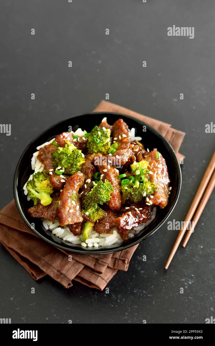 Rindfleisch und Brokkoli unter Rühren mit Reis in einer Schüssel braten Stockfoto