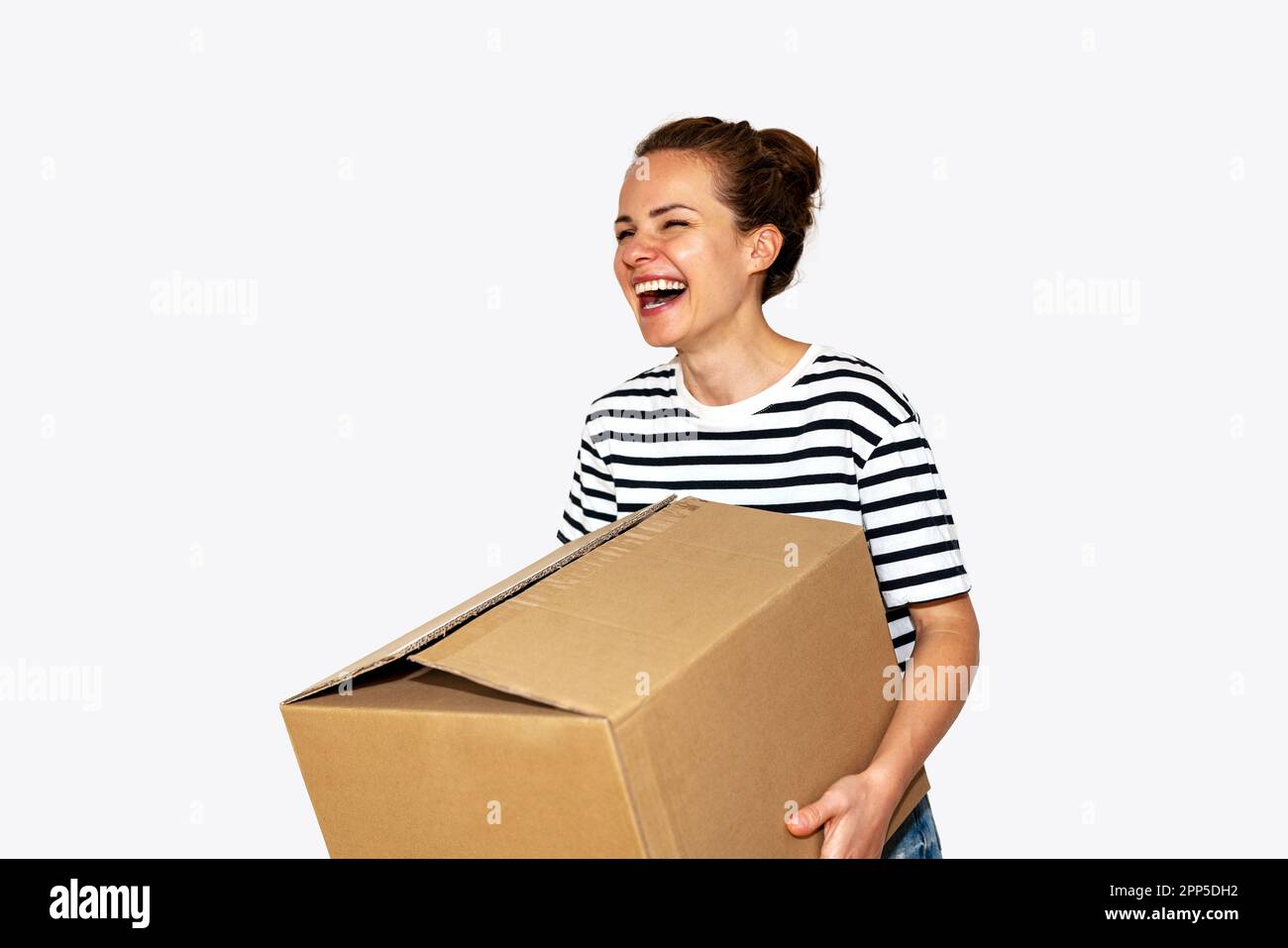 Eine Frau, die eine große Pappschachtel in der Hand trägt und lacht, bewegt und umzieht. Stockfoto
