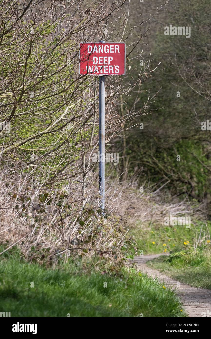 Warnschild „Gefahr tiefes Wasser“, das Besucher auf eine Ertrinkungsgefahr in einem regionalen Naturschutzgebiet in Großbritannien aufmerksam macht. Stockfoto