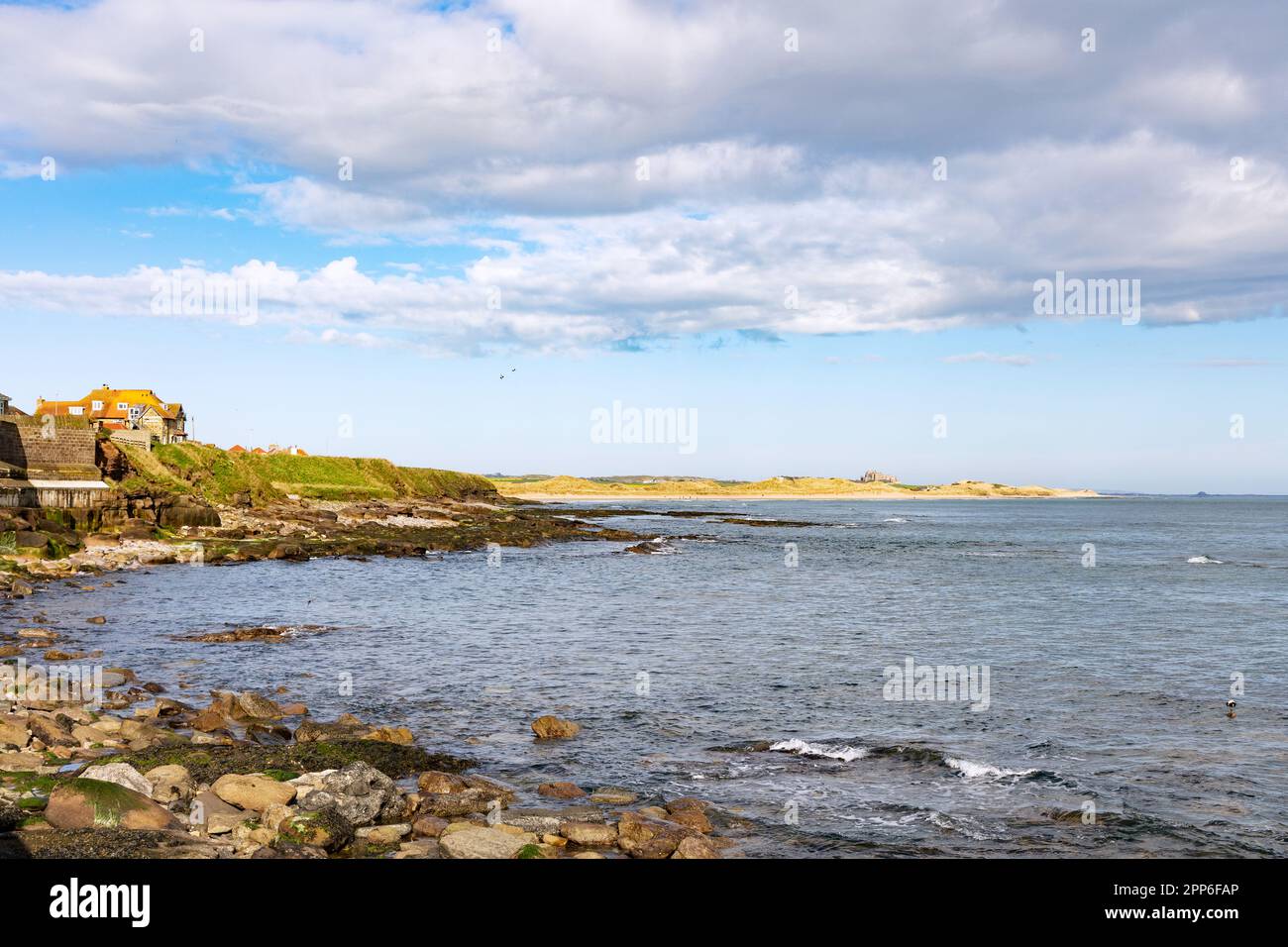 Northumberland Coast UK - Küstenlandschaft mit Blick nach Norden vom Seahouses Village bis Bamburgh Castle in der Frühlingssonne, Northumberland UK Stockfoto