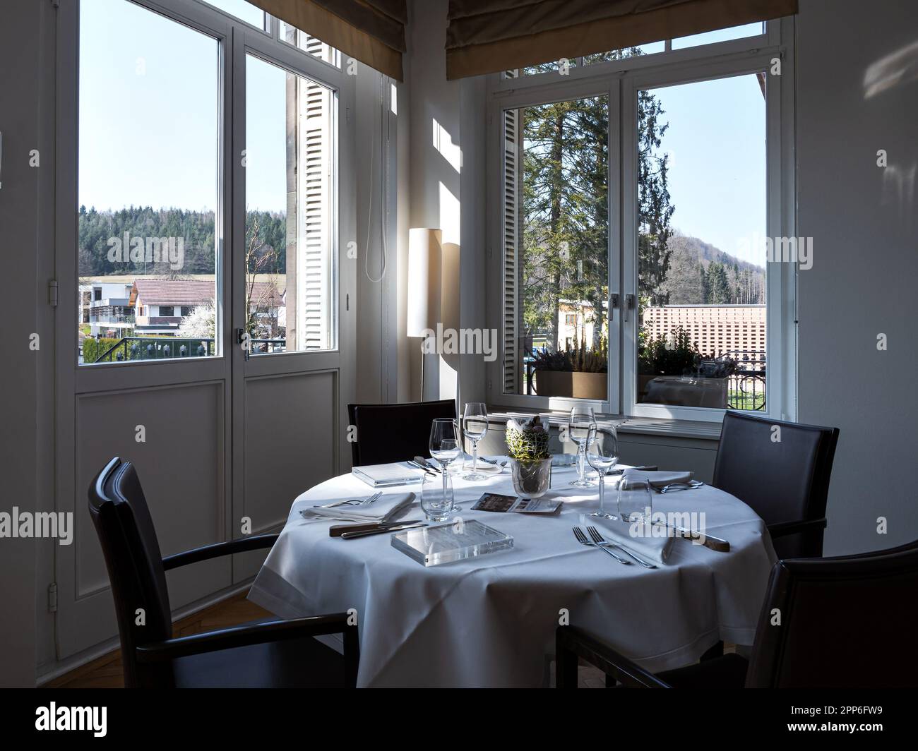 Gemütliches Interieur des Restaurants. Raum gefüllt mit der Morgensonne. Tische sind gedeckt und bereit für den Empfang der Gäste. Wärme und Tragekomfort. Stockfoto