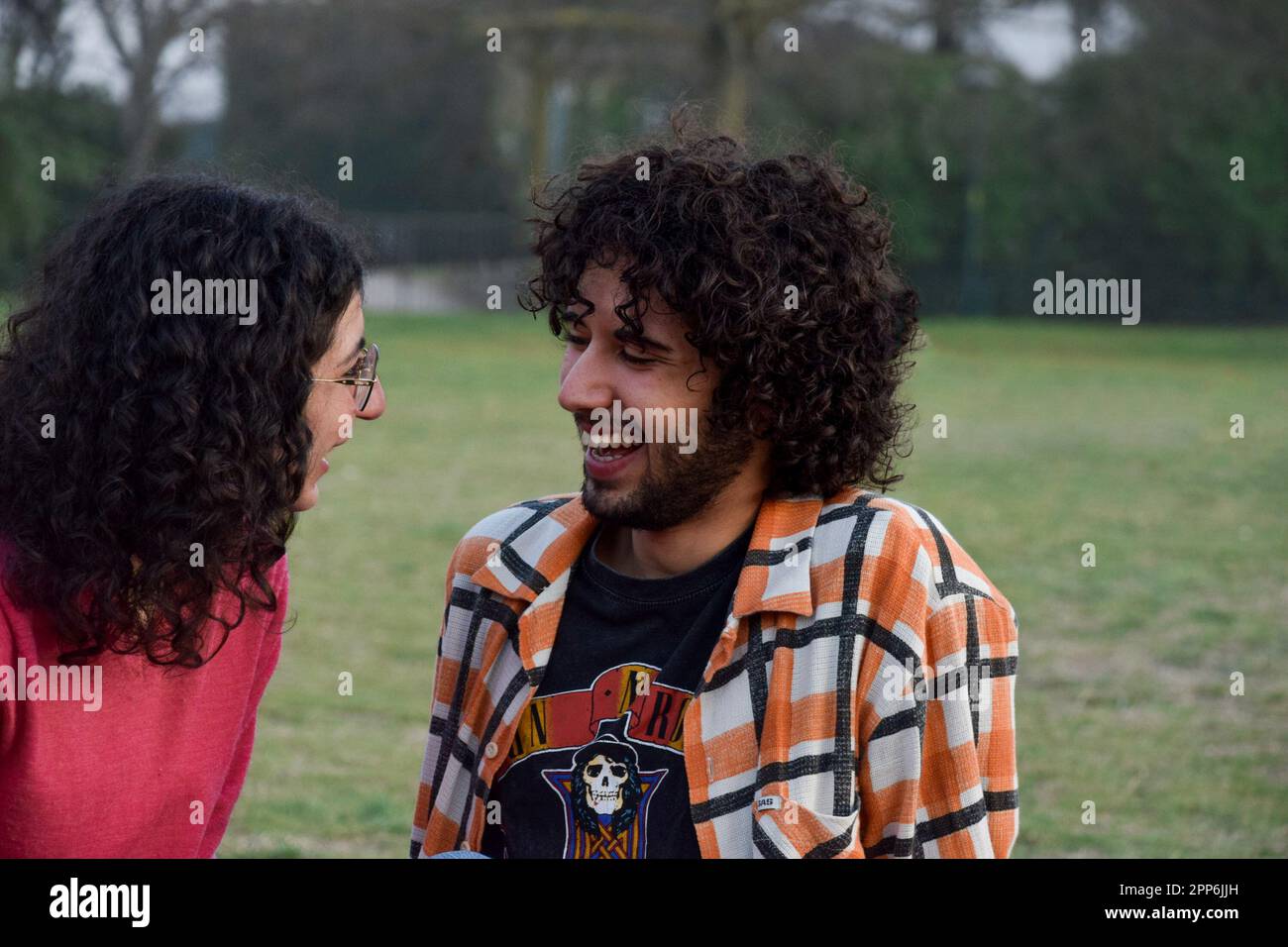 Ein paar Freunde saßen im Park und unterhielten sich und amüsierten sich Stockfoto