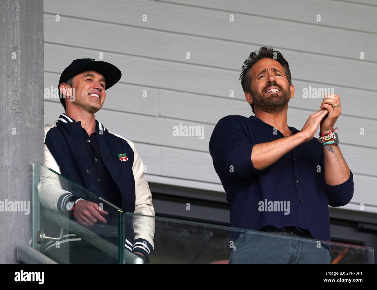 Wrexham Miteigentümer Rob McElhenney (links) und Ryan Reynolds reagieren auf den Tribünen während des Spiels der Vanarama National League auf dem Rennplatz Wrexham. Foto: Samstag, 22. April 2023. Stockfoto