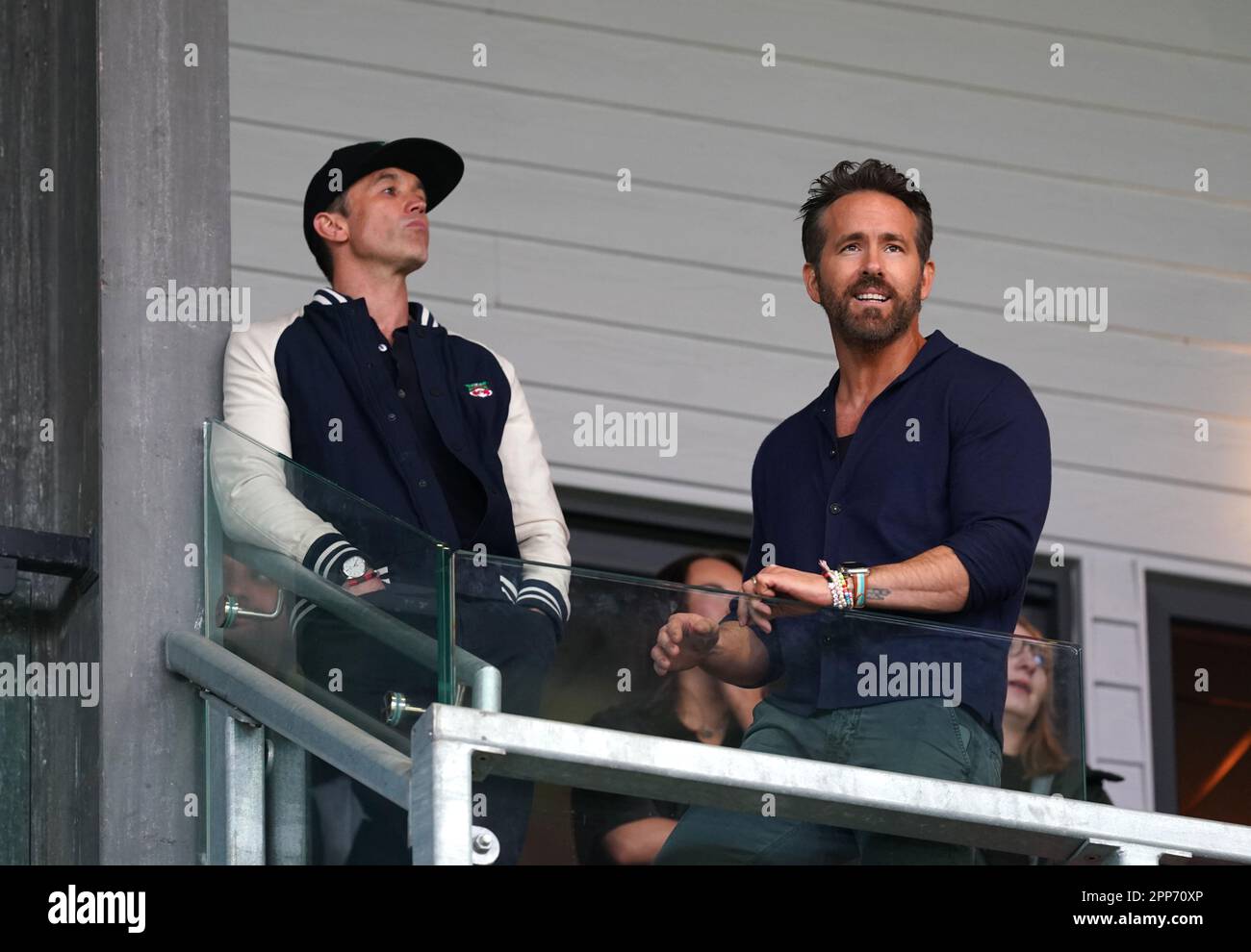 Wrexham Miteigentümer Rob McElhenney (links) und Ryan Reynolds reagieren auf den Tribünen während des Spiels der Vanarama National League auf dem Rennplatz Wrexham. Foto: Samstag, 22. April 2023. Stockfoto
