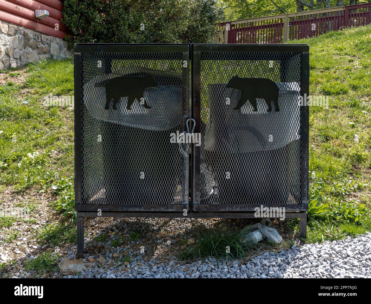 Neben einer Blockhütte in den Smokey Mountains in der Nähe von Pigeon Forge, Tennessee, USA, befinden sich bärensichere Müllcontainer oder Anti-Bär-Mülltonnen. Stockfoto
