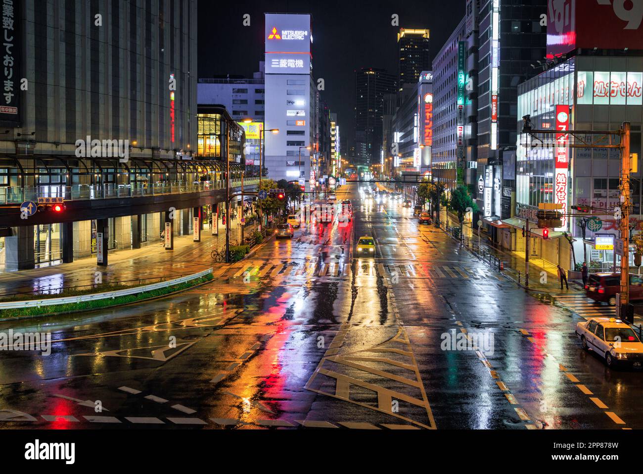 Osaka, Japan - 12. April 2023: In regnerischen Nächten reflektieren nasse Straßen in der Innenstadt von Osaka die Lichter Stockfoto