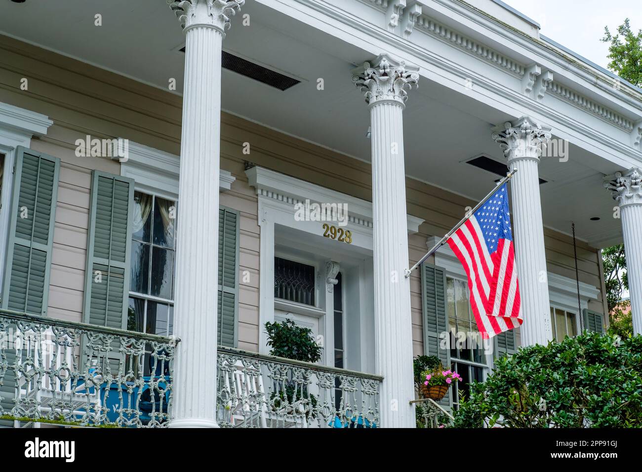 NEW ORLEANS, LA, USA - 18. APRIL 2023: Vordereingang mit amerikanischer Flagge und Veranda des historischen Michael Hans House im Garden District Stockfoto