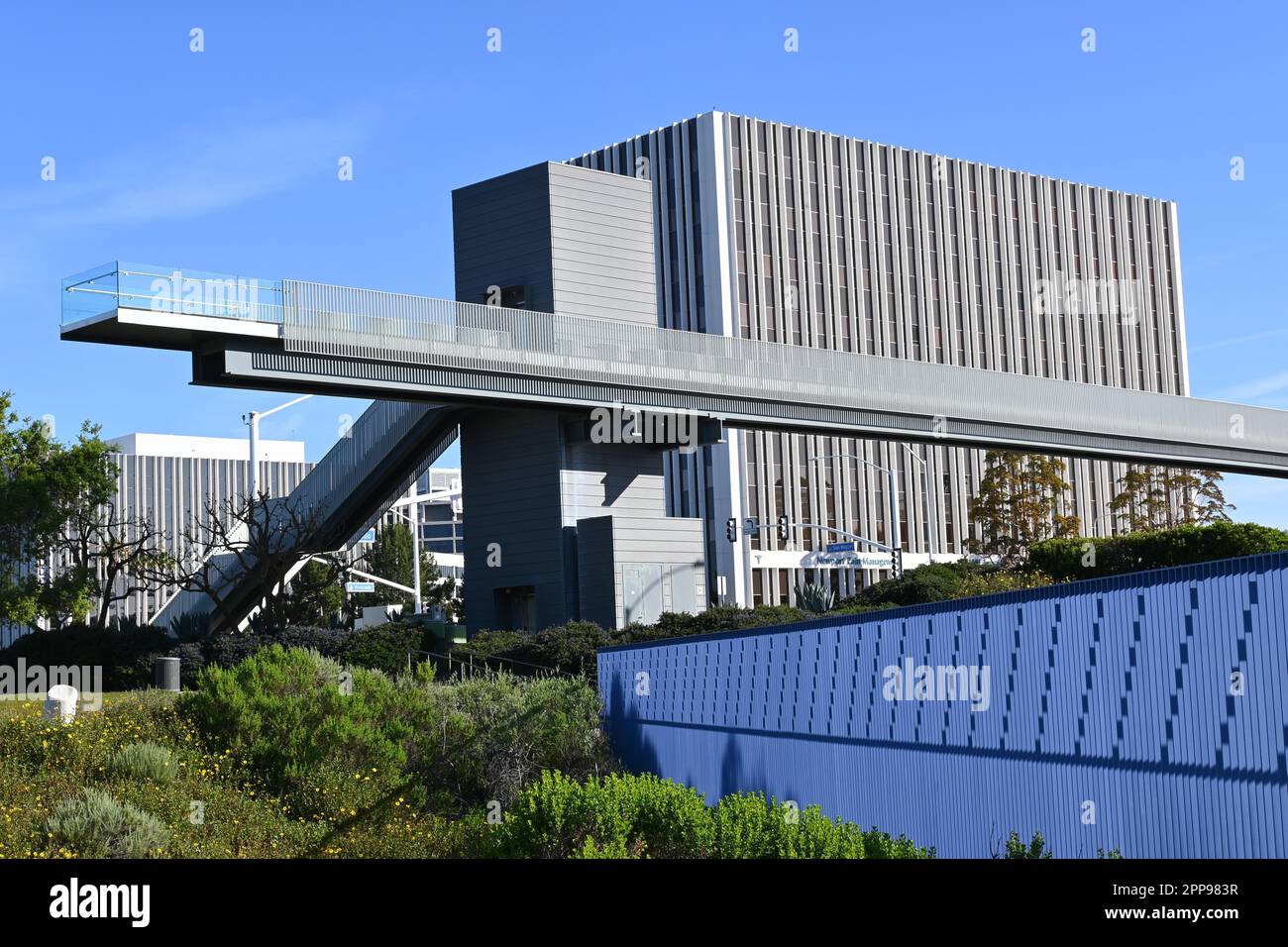 NEWPORT BEACH, KALIFORNIEN - 22. April 2023: Fußgängerbrücke über den San Miguel Drive, der die beiden Hälften des Civic Center Park mit den Bürogebäuden i verbindet Stockfoto