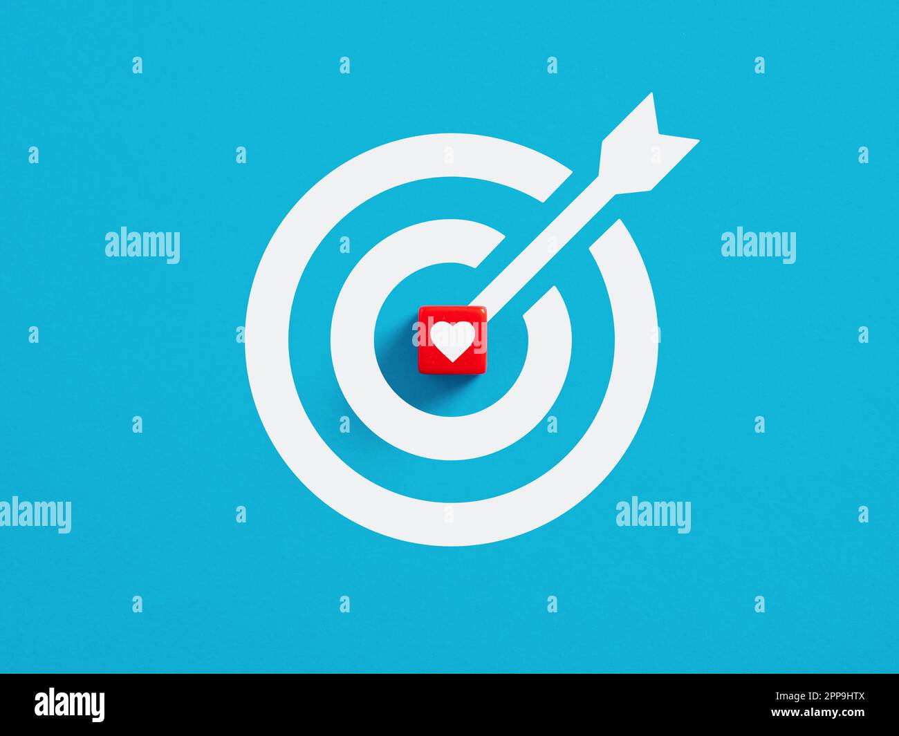 Ich liebe das Zielkonzept. Ziel ist es, Liebe, Glück und eine Beziehung zu finden. Roter Würfel mit Herzliebenssymbol in der Mitte eines Zielschilds. Stockfoto
