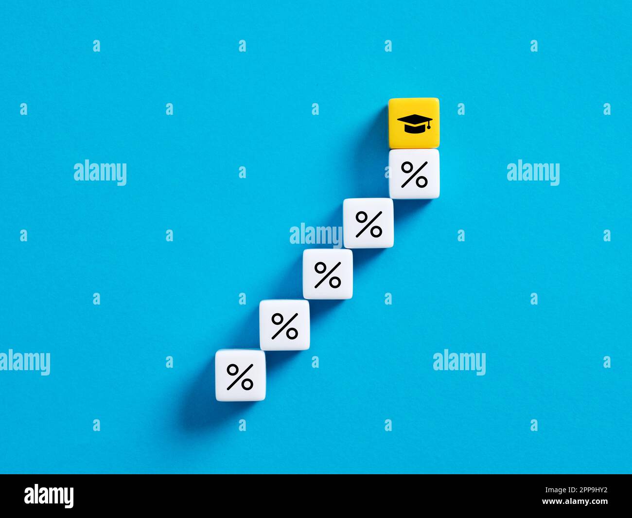 Studentenschulden, Stipendiendarlehen und Bildungsinvestitionen. Prozentzeichen und Großbuchstaben auf Würfeln. Stockfoto