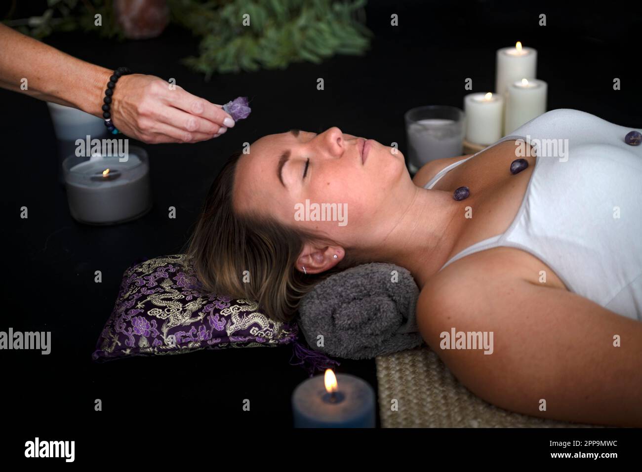 Frauen- und Energieheilung vor schwarzem Hintergrund Stockfoto