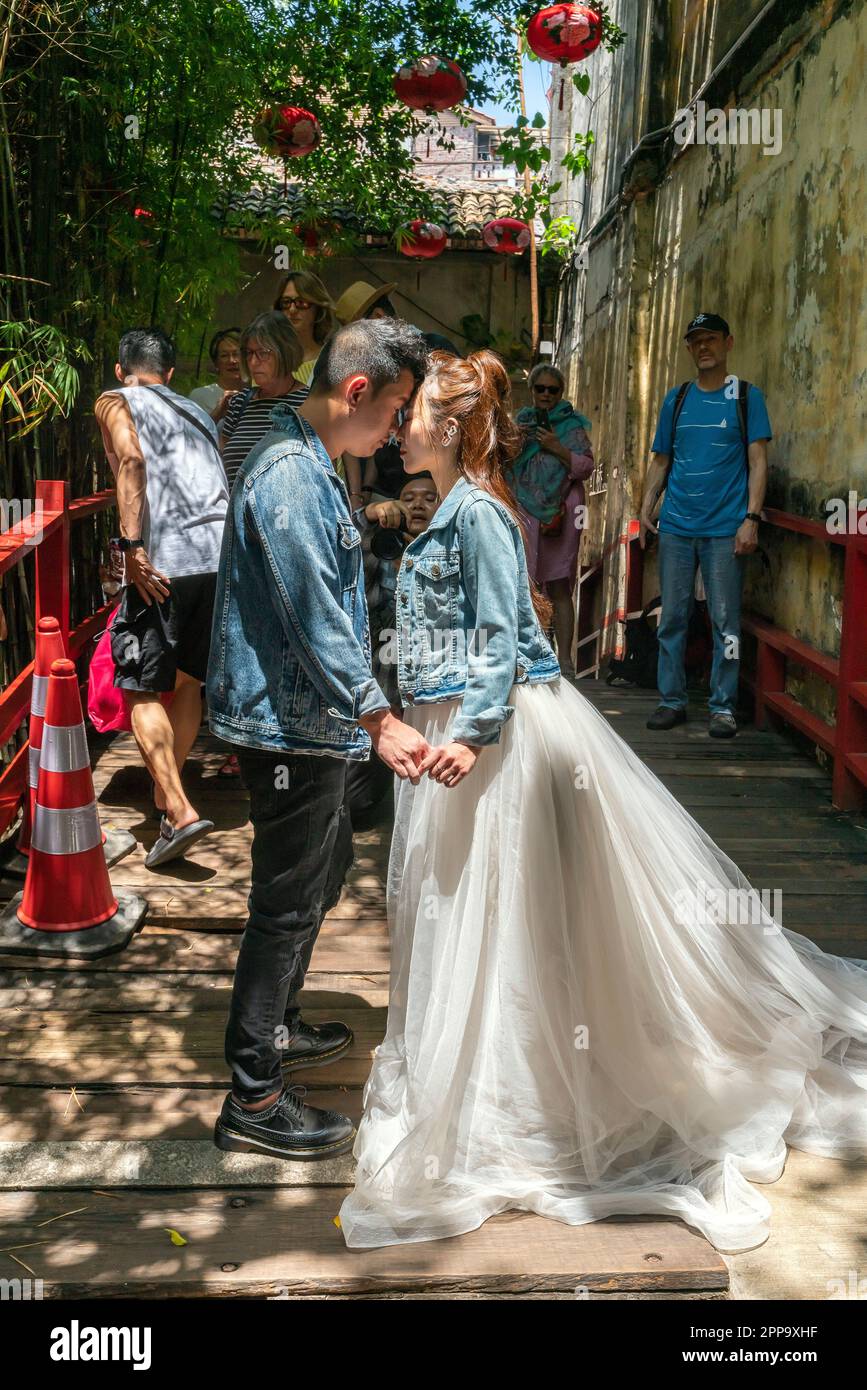 Lokaler Fotograf, der auf einer Nebenstraße, umgeben von einer Ansammlung von Vorkriegshäusern, Hochzeit schießt. Altstadt Von Kuala Lumpur Malaysia. Stockfoto