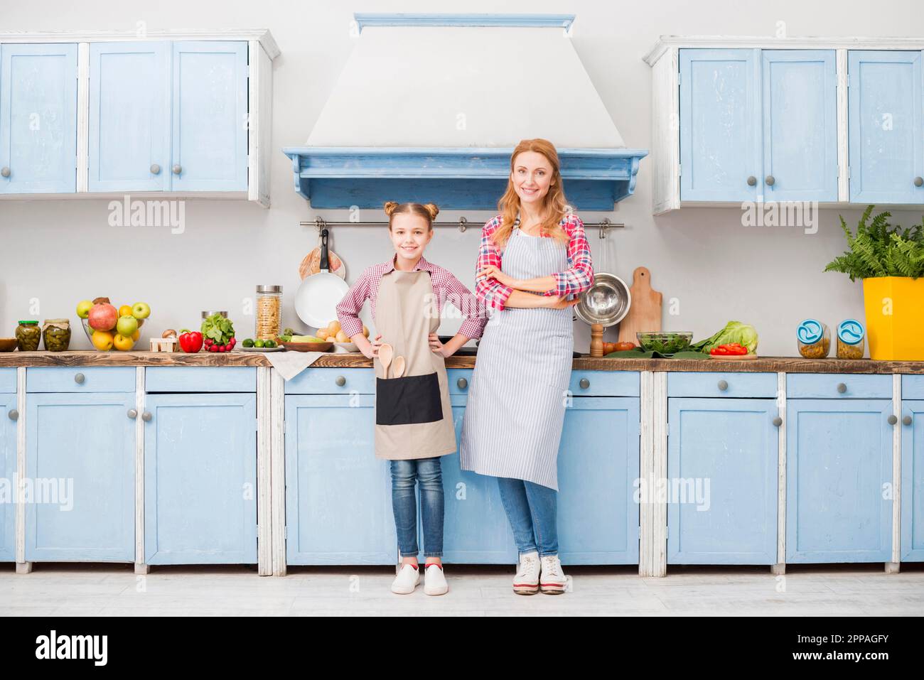 Portrait glückliche Mutter Tochter Schürze stehende Küche Stockfoto