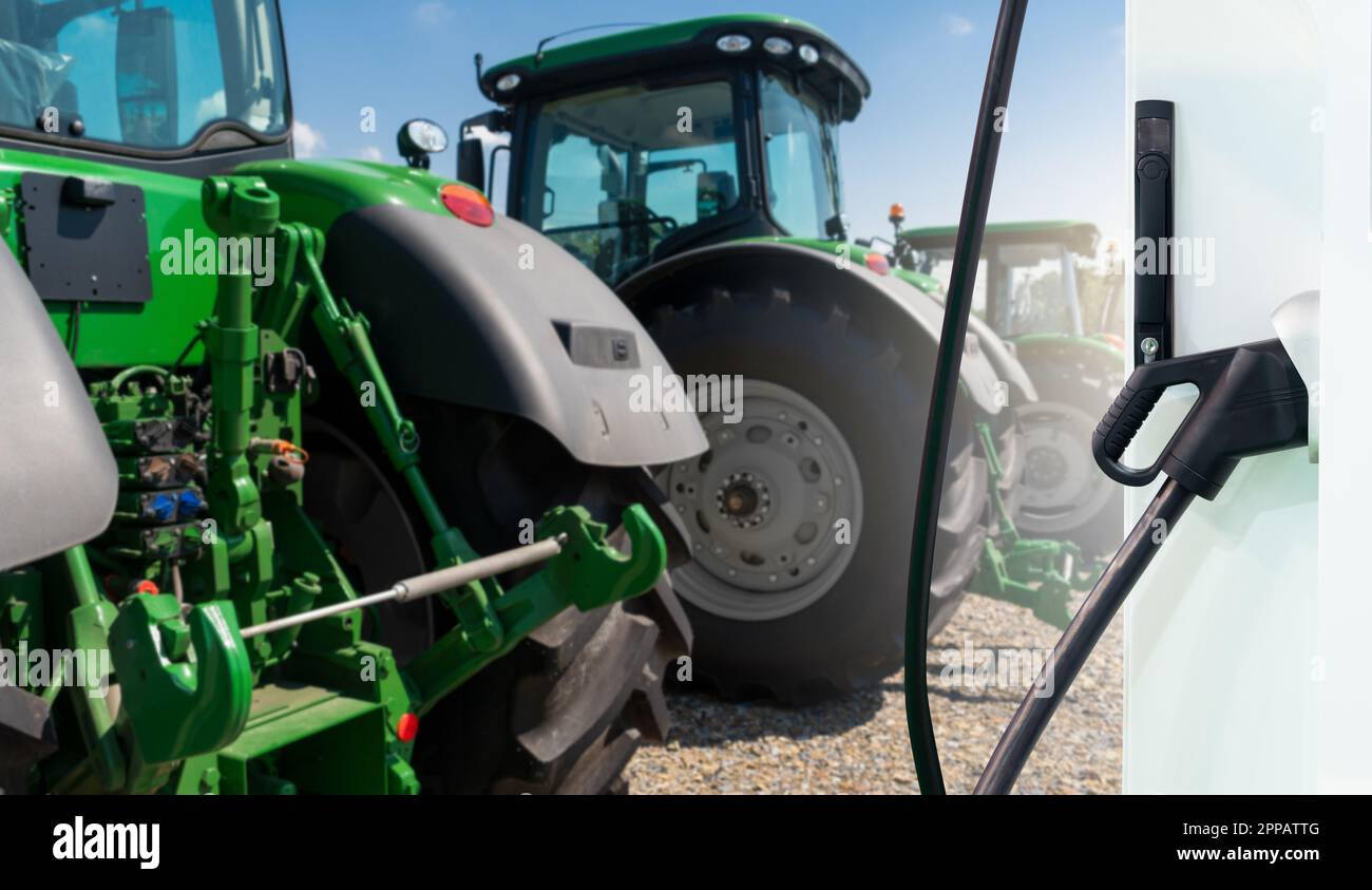 Ladestation für Elektrofahrzeuge im Hintergrund landwirtschaftlicher Traktoren. Konzept. Hochwertiges Foto Stockfoto