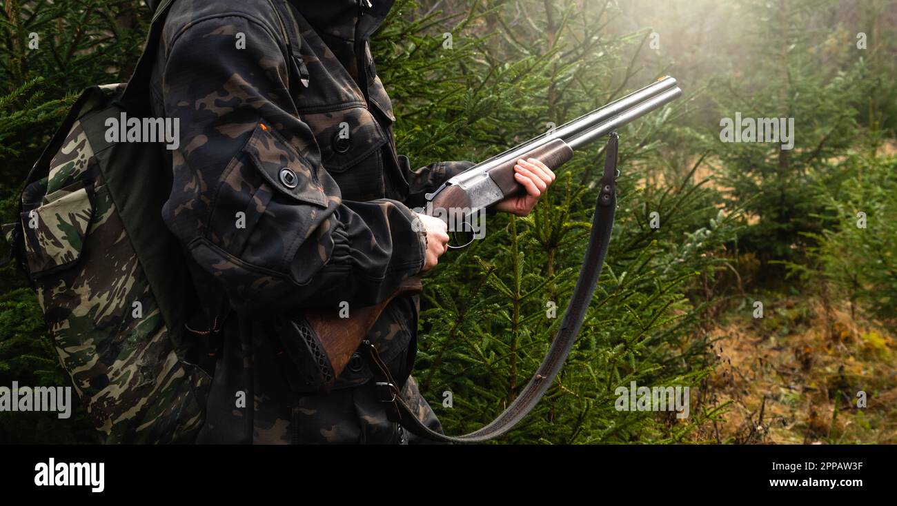 Jäger mit einer Waffe und einem Rucksack im Wald. Hochwertiges Foto Stockfoto