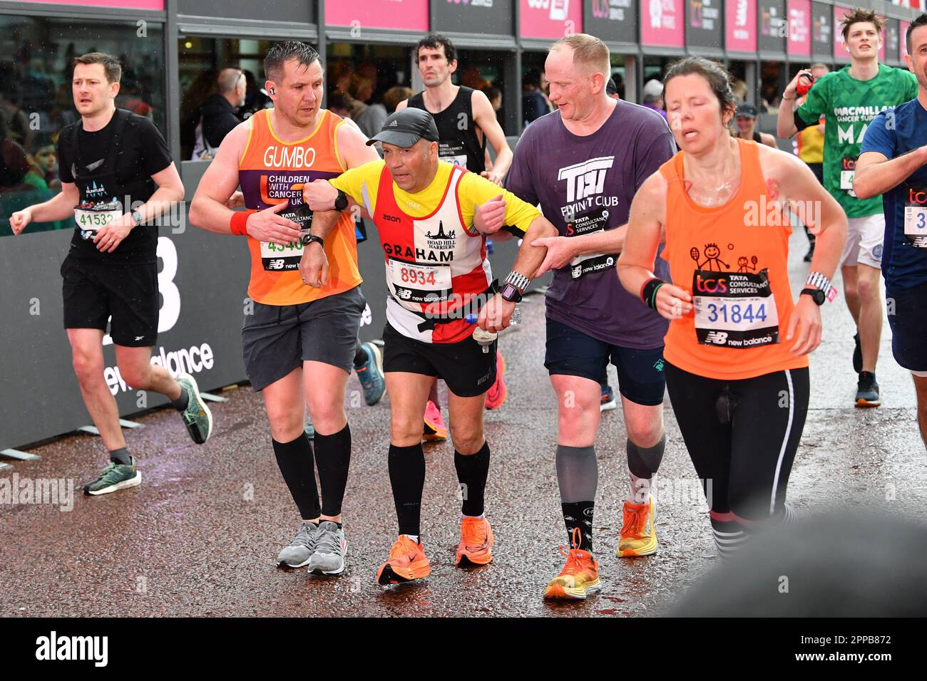 London, Großbritannien. 23. April 2023. TCS 2023 London Marathon; zwei Läufer helfen sich über die Ziellinie gegenseitig. Credit: Action Plus Sports/Alamy Live News Stockfoto