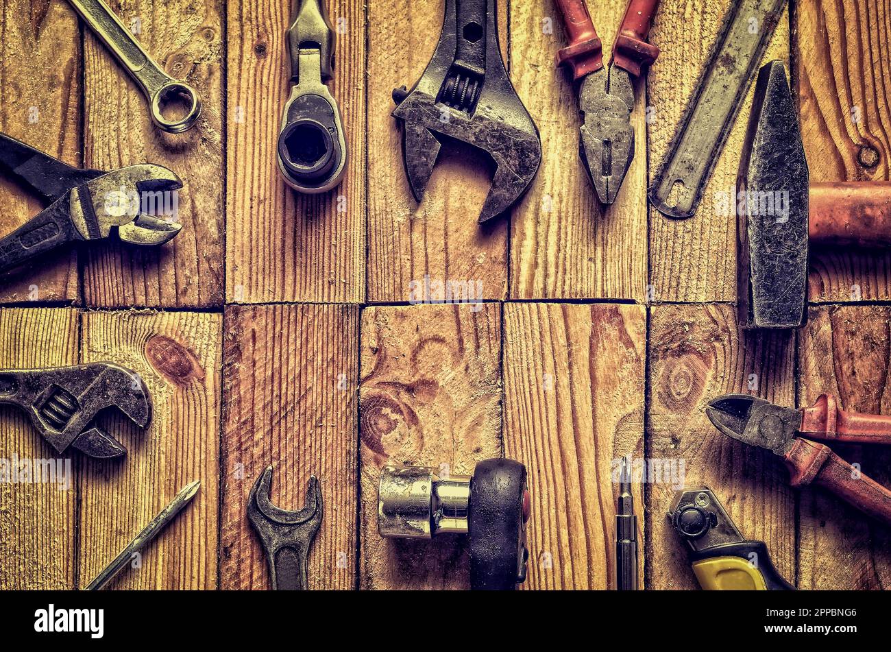 Rahmen aus Werkstattwerkzeugen auf Holz. Schraubenschlüssel, Ringschlüssel, Hammer, Flachfeile, Zange, Schraubendreher, Affenschlüssel auf natürlichem Holzgrund. Stockfoto