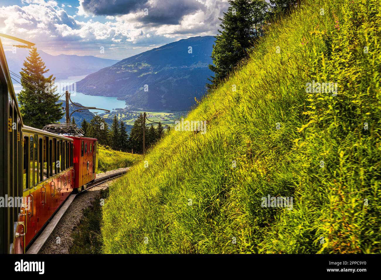 Roter Touristenzug, der von Wilderswil in der Nähe von Interlaken zu den berühmten Wildblumengärten der Schynige Platte in der Schweiz fährt. Retro-Zug bewegt sich f Stockfoto