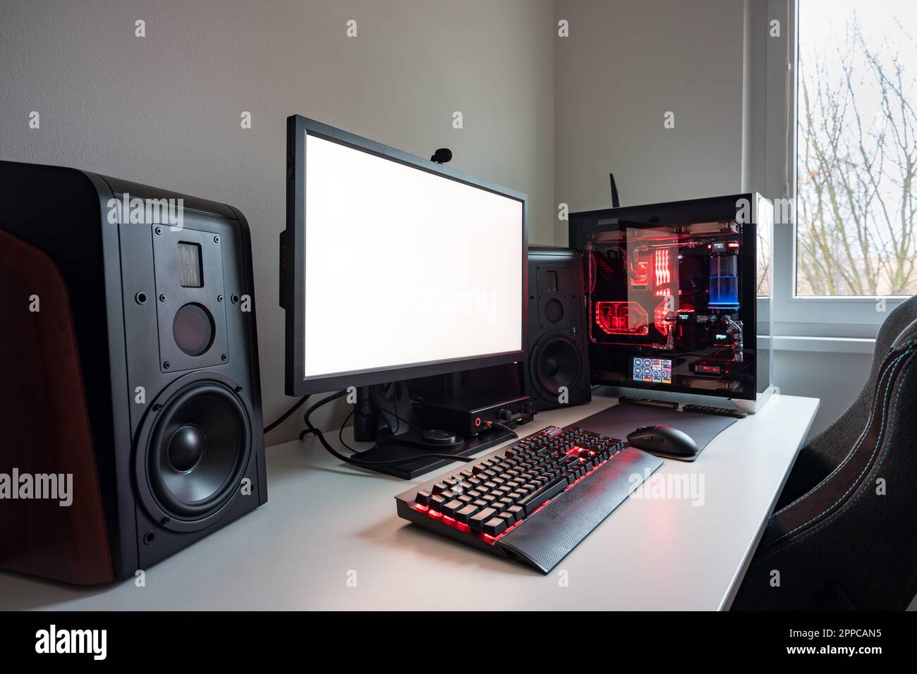 Maßgeschneiderter Gaming-Computer mit weißem Bildschirm, Tastatur, Maus, Desktop-PC, Komponenten, Hardware, Spielstuhl. Moderne PC-Gaming-Einrichtung auf dem Schreibtisch. Mod Stockfoto