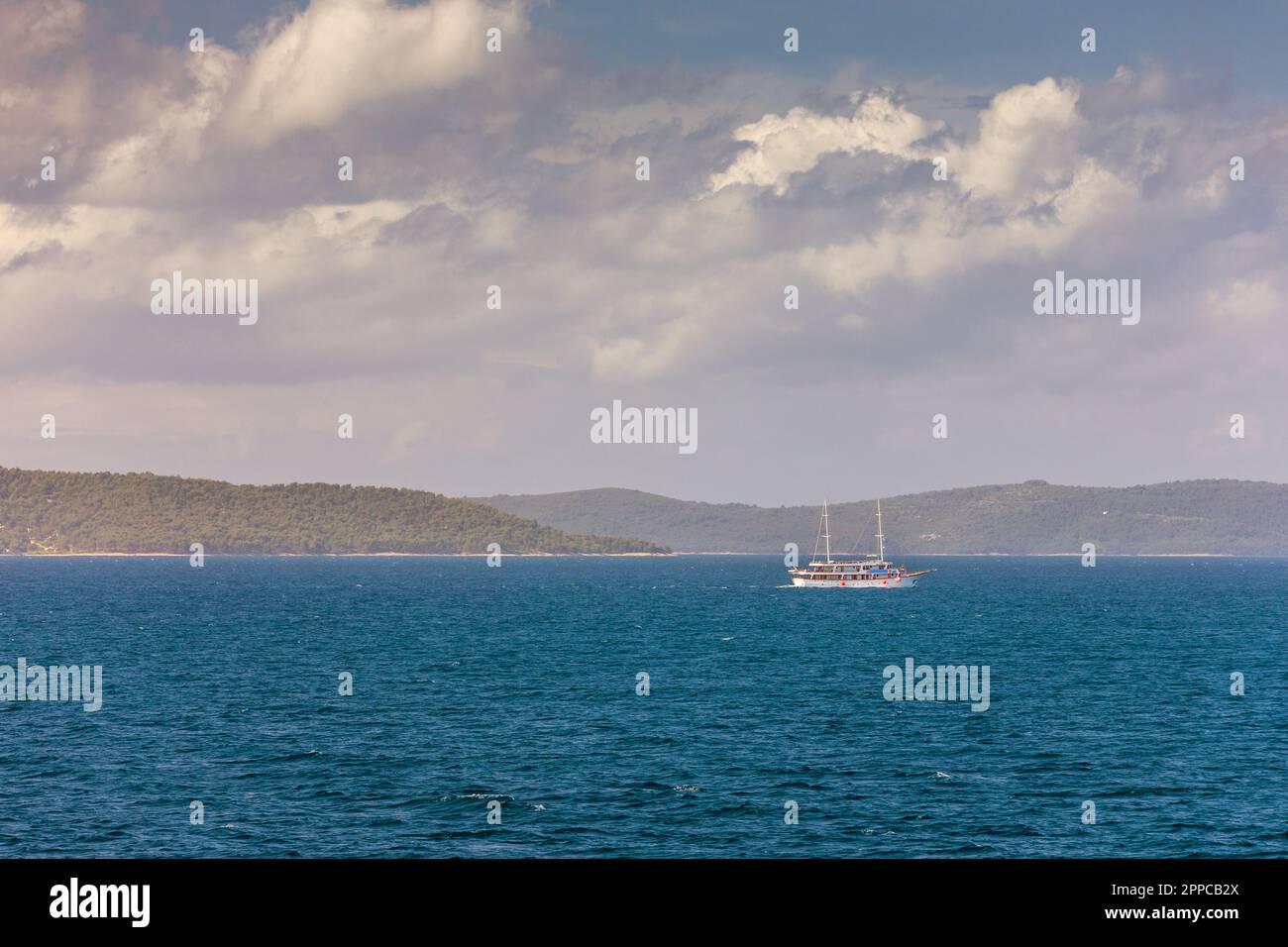 Segelboot im Meer in der Abendsonne mit Bergen im Hintergrund, Luxus Sommer Abenteuer, aktiven Urlaub im Mittelmeer, Kroatien. Segeln Stockfoto