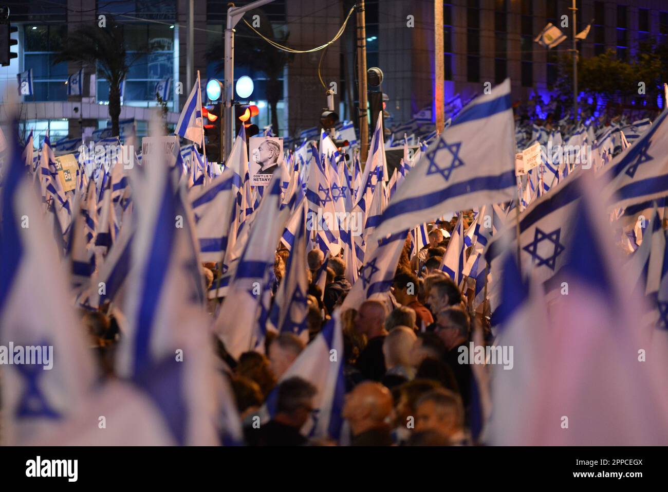 Israel. 22. April 2023. Demonstranten gegen die Gesetzesüberholung schwenken die israelische Flagge und tragen ein Schild mit Ministerpräsident Bnejamin Netanjahus Foto mit Pinocchio Nose bei einer Demonstration in Tel Aviv. April 22. 2023. (Matan Golan/Sipa USA). Kredit: SIPA USA/Alamy Live News Stockfoto