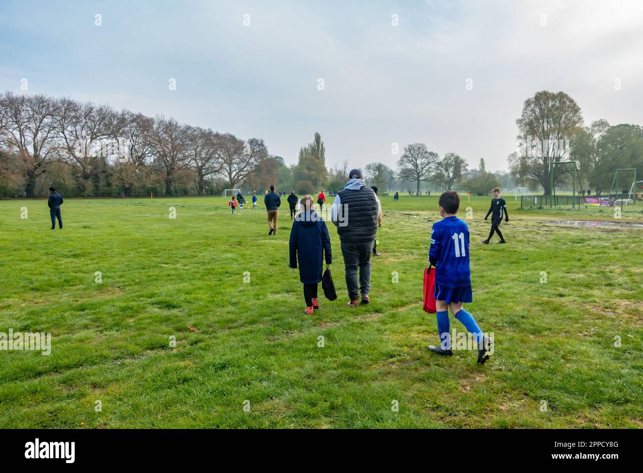 Besucher, die in Kings Maadow Park in Reading, Großbritannien, ankommen, um an einem Samstagmorgen ein Fußballspiel für Kinder im Rahmen der BYDL-Sommerliga zu erleben Stockfoto