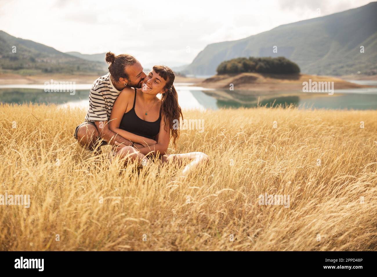 Ein glücklicher Mann umarmt eine Frau vor dem Rama Lake Stockfoto