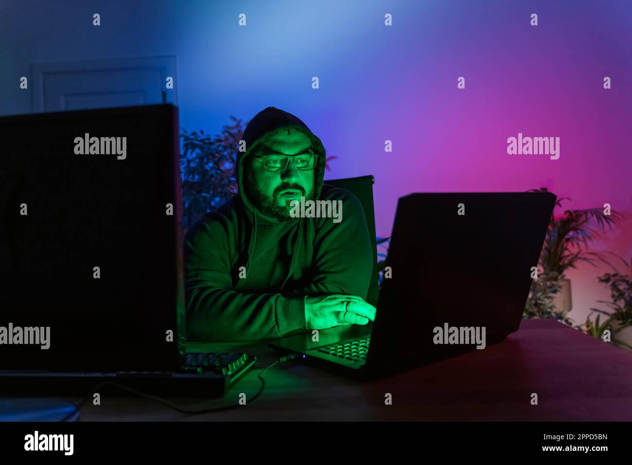 Hacker mit Computern auf dem Schreibtisch zu Hause Stockfoto