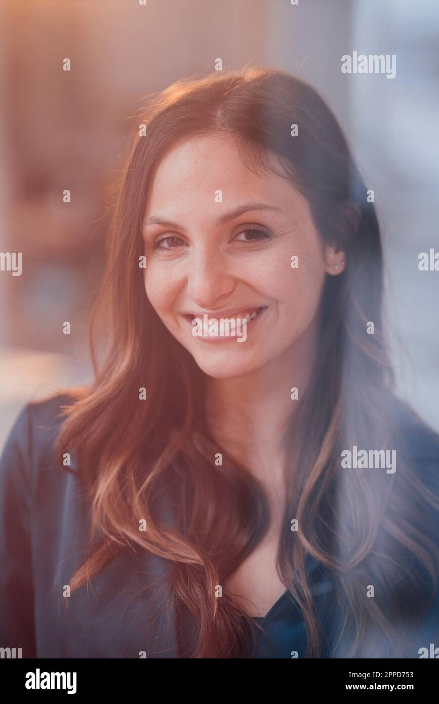 Glückliche junge Frau mit braunem Haar, durch Glas gesehen Stockfoto