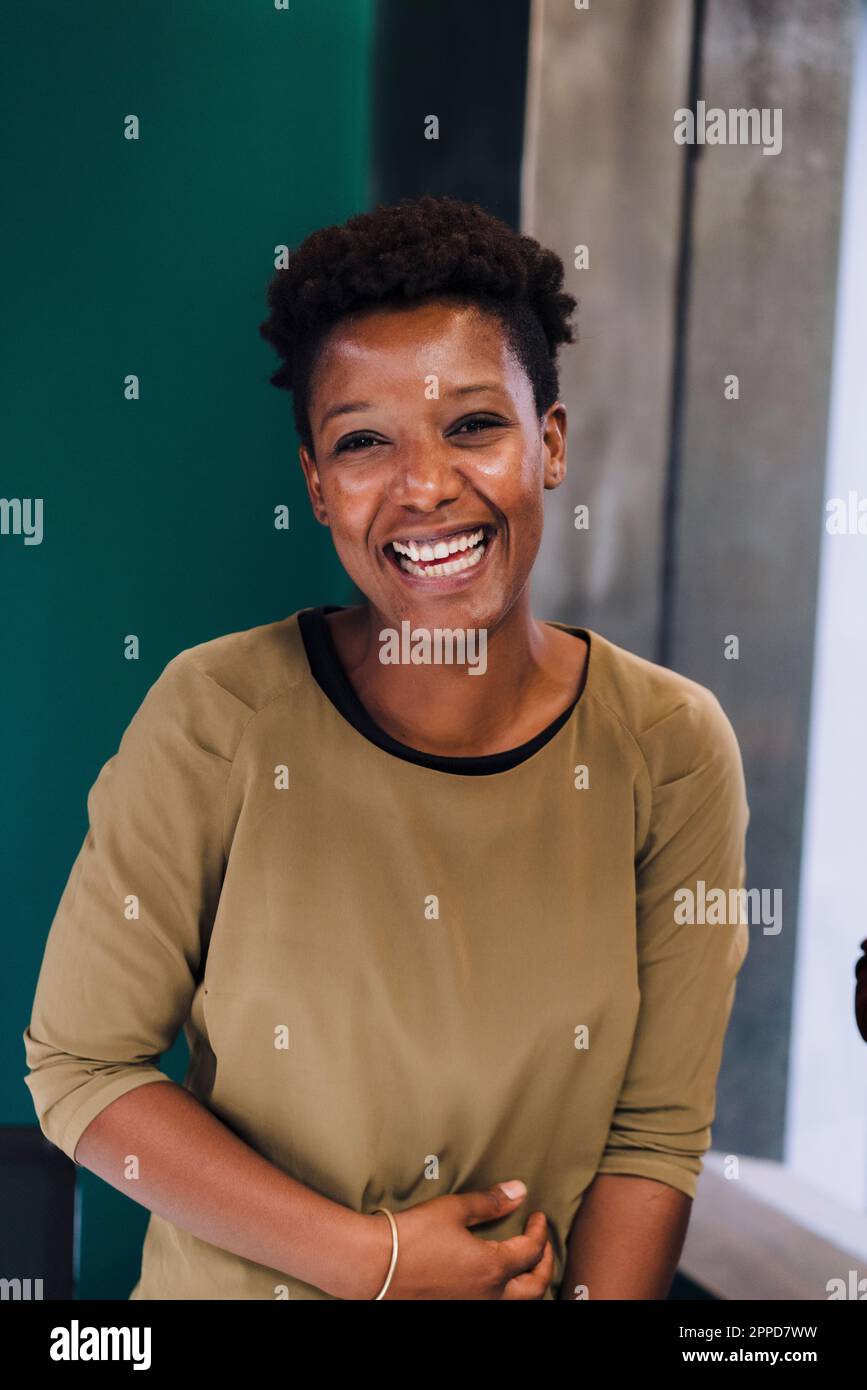 Glückliche Geschäftsfrau mit kurzen Haaren im Büro Stockfoto