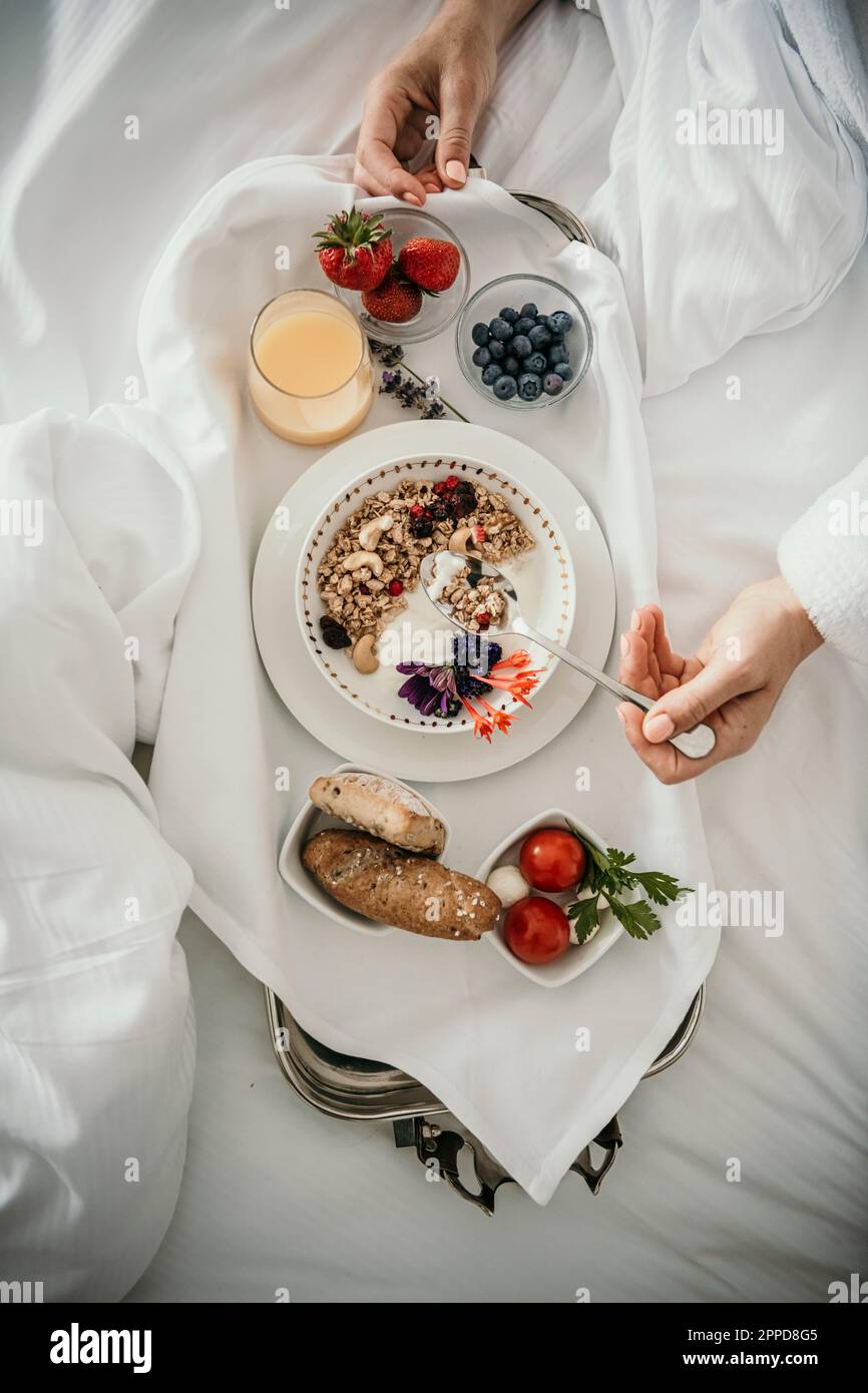 Frau frühstückt zu Hause im Bett Stockfoto