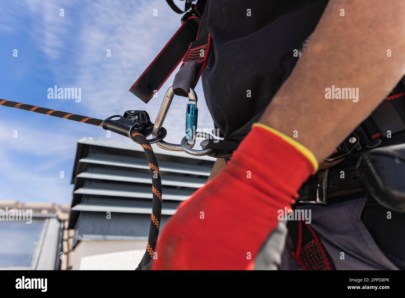 Techniker trägt Auffanggurt auf dem Dach Stockfoto