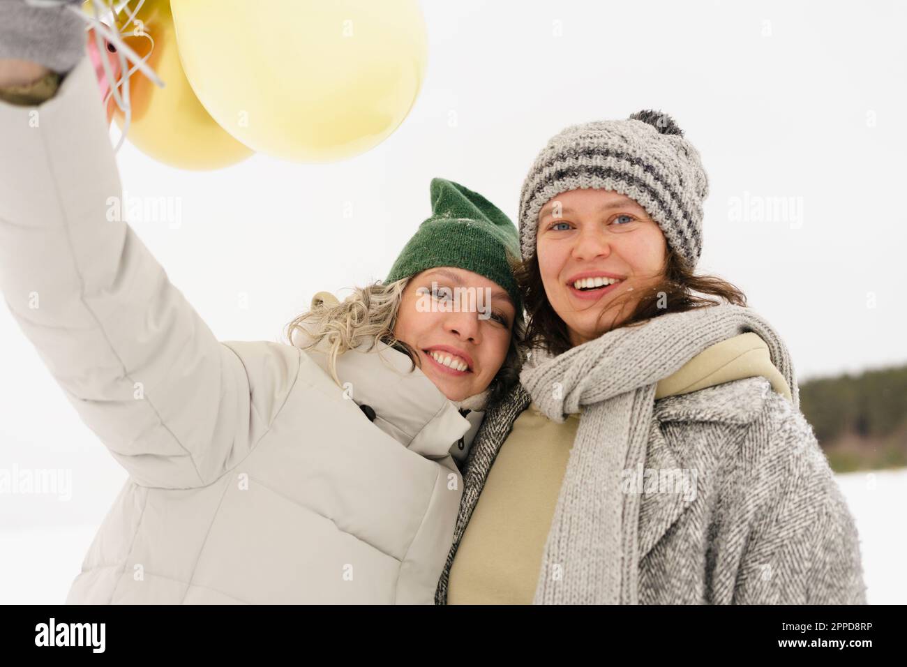 Glückliche Frauen, die Strickmützen tragen und den Winter genießen Stockfoto