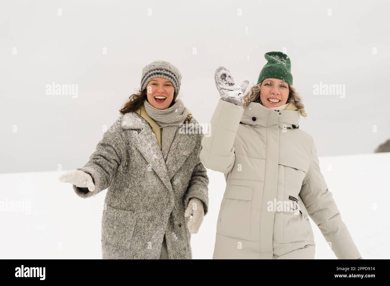 Fröhliche Freunde, die Spaß haben, Schnee im Winter zu werfen Stockfoto